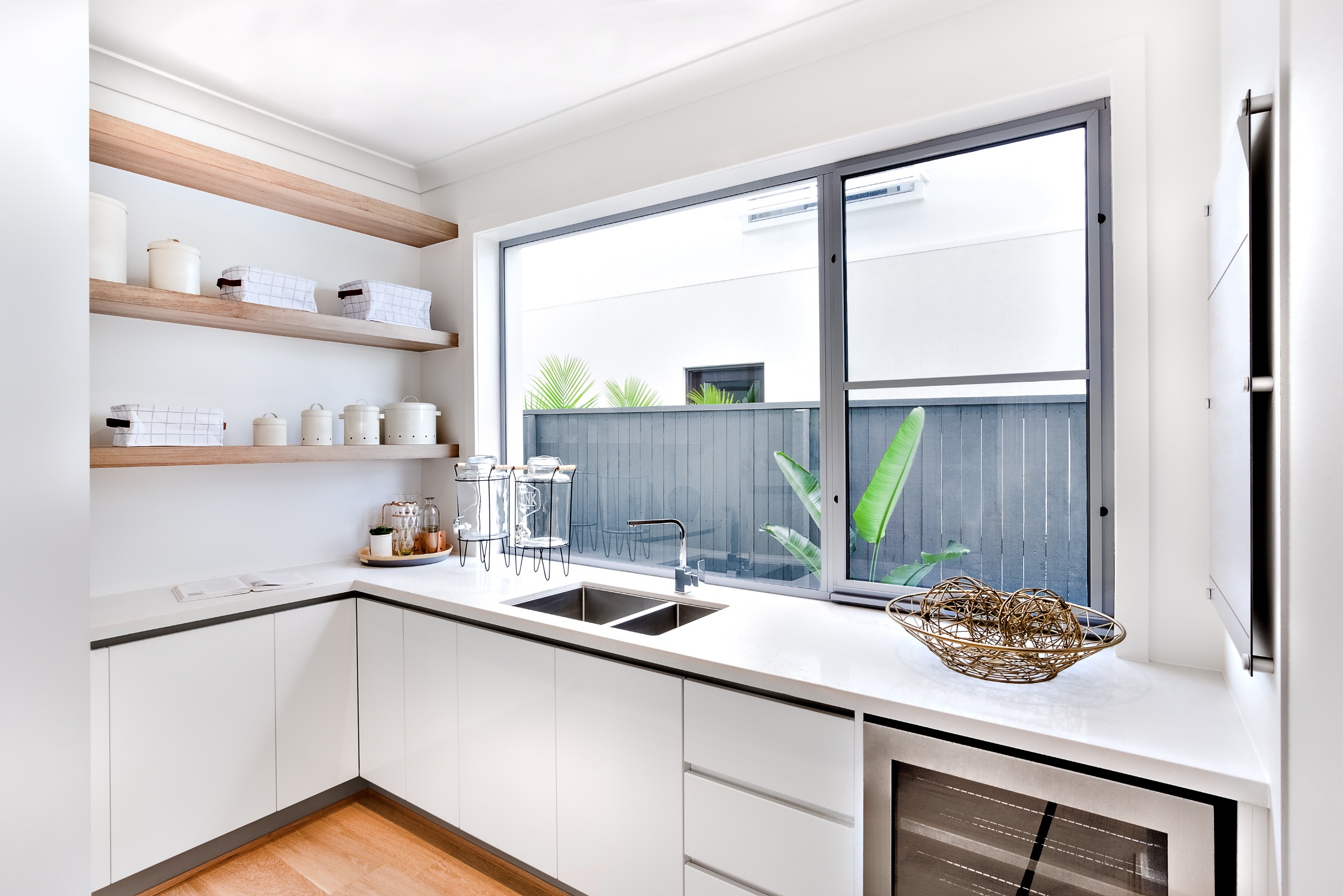 In small kitchens, replace cabinets with floating shelves for space and light.