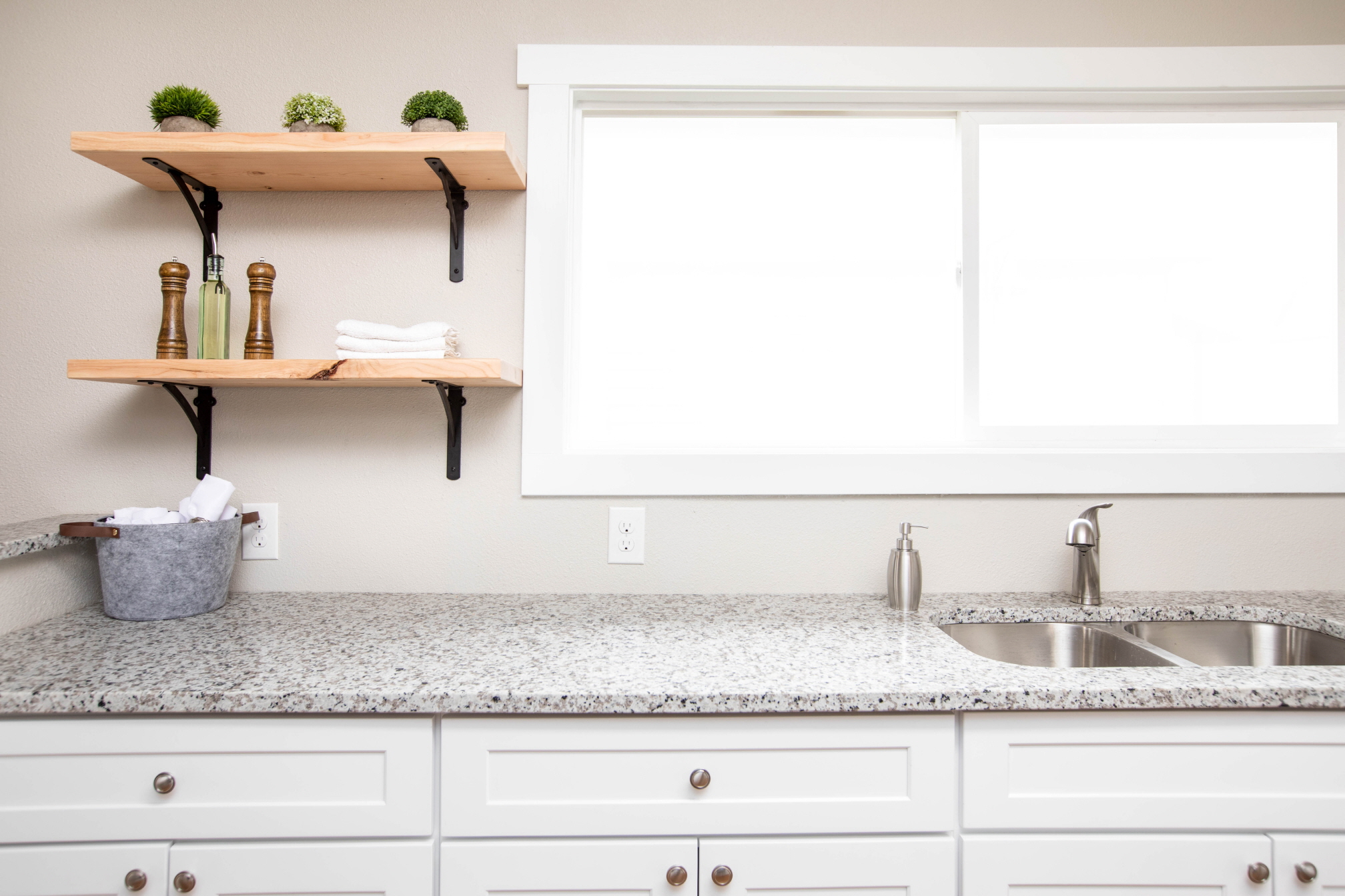 Floating shelves enhance kitchen storage while maintaining a bright and airy ambiance.