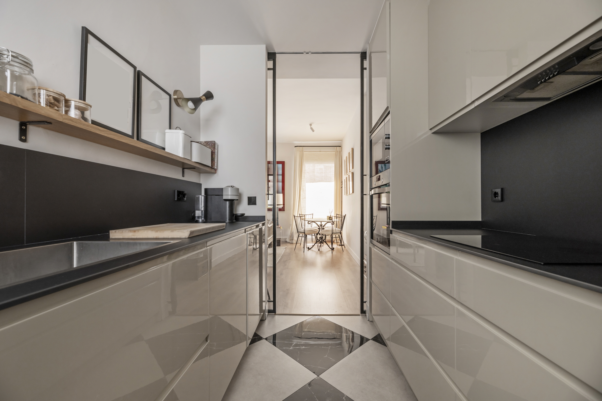 The combination of black countertops and black-and-white checkered floors brings a fresh retro vibe to your kitchen.